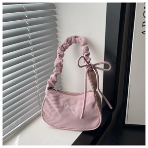 Gros plan détaillé du sac en velours côtelé rose avec broderie nœud blanc et poignée plissée