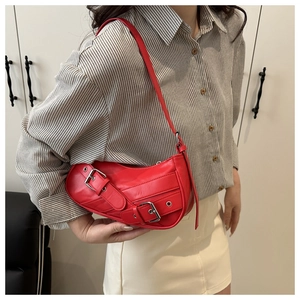 Detail view of red crescent hobo bag with vintage motorcycle buckle and silver eyelets