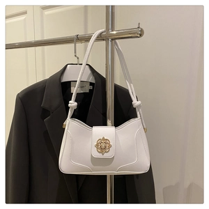 Détail d'un sac demi-lune blanc avec boucle dorée vintage et bandoulière à nœuds