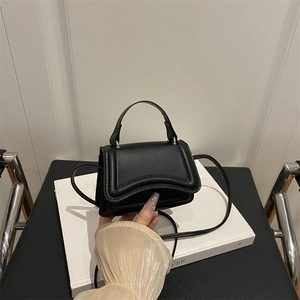 Mini borsa nera minimalista con patta ondulata e manico superiore in stile moderno