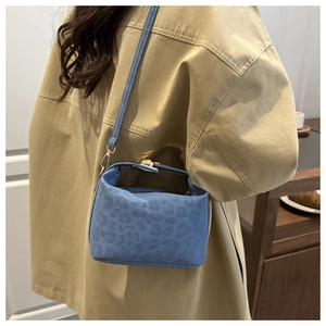 Detailed macro view of the blue leopard texture and golden zipper on this small crossbody bag