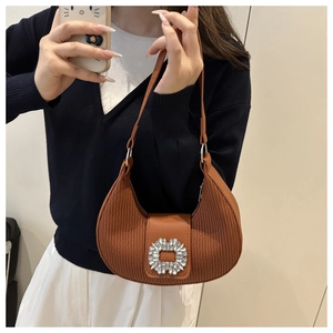 Selfie miroir montrant le sac à bandoulière marron plissé avec boucle en strass brillant