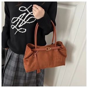 Detailed view of brown faux suede tote bag with decorative strap and golden D-ring buckle