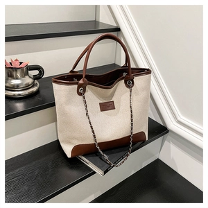 Bolso tote de lona beige con ribete de cuero marrón y correa de cadena metálica
