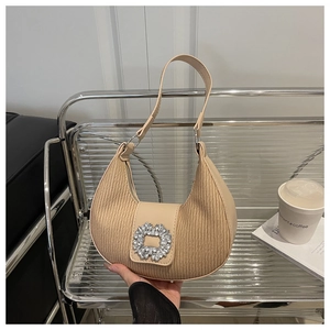 Détail du sac hobo beige avec texture plissée et boucle ornée de strass brillants