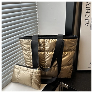 Détail d'un grand sac cabas matelassé doré métallisé avec sa pochette assortie