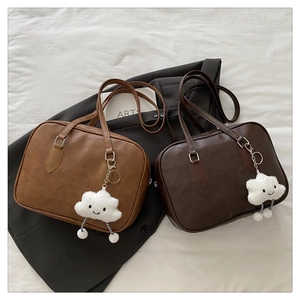 Detail view of vintage leather shoulder bags with cute white cloud plush charms