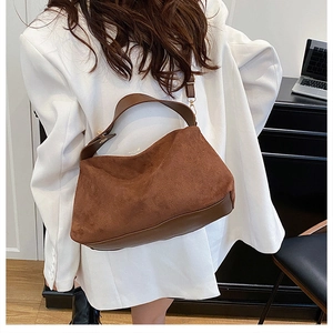 Rear view of model wearing a large dark brown suede tote bag with crescent design