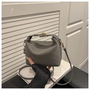 Detail der grauen Handtasche aus Wildlederimitat mit goldener Schließe und Trageriemen