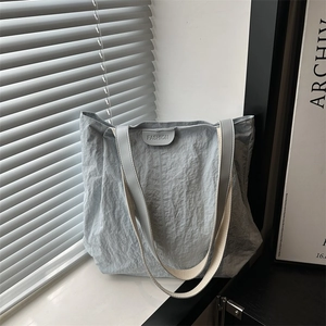 Minimalist light grey pleated nylon tote bag with fashion tag and shoulder straps