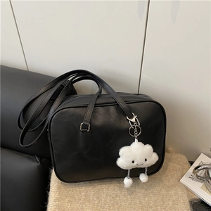 Minimalist black faux leather Boston bag with cute plush cloud pendant on knit background