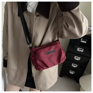 Detail of burgundy waterproof nylon crossbody bag with JINGPIN logo and adjustable strap