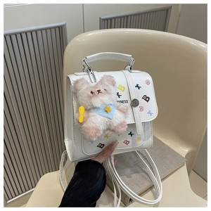 White mini backpack featuring printed colorful B letter and a cute plush bear charm detail