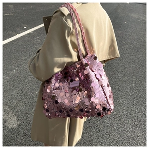 Detailed close-up of pink sequin tote bag with woven shoulder strap and brand label