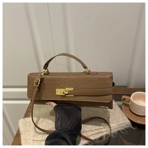 Detail of brown crocodile pattern handbag with gold twist lock and handheld grip style