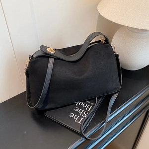 Minimalist black faux suede tote bag with leather trim and gold metal buckle detail