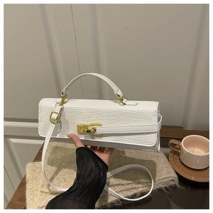 Detailed close-up of white crocodile pattern texture and golden rotating lock on the bag