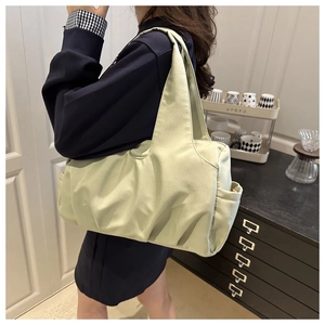 Détail de la poche latérale et du tissu en nylon plissé doux sur le sac à bandoulière vert