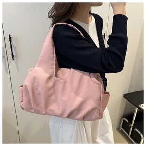 Vue détaillée d'un sac cabas léger en nylon rose imperméable porté par un mannequin