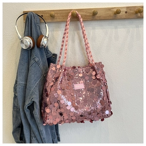 Close-up of pink sequin tote bag with woven rope handle and branded fashion patch