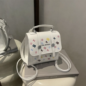White minimalist leather backpack with colorful letters and decorative metal buckle straps