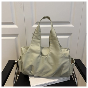 Détail du sac cabas vert clair avec texture plissée et poche latérale pratique