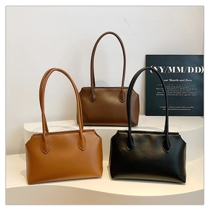 Three minimalist shoulder bags in caramel, coffee, and black displayed on curved white stands