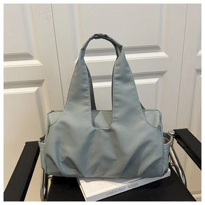 Détail d'un sac cabas en nylon bleu clair avec texture plissée et poche latérale