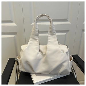 Détail d'un grand sac cabas blanc matelassé avec poches latérales et fermeture éclair