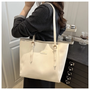 Detail of off-white tote bag showing PU leather texture and adjustable metal buckle