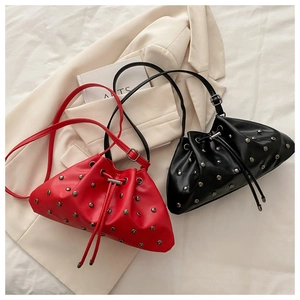 Flat lay of red and black bucket bags with silver studs and drawstring closure