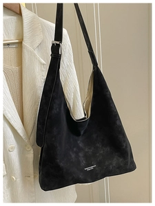Détail du sac cabas en daim noir avec logo blanc et boucle de sangle argentée