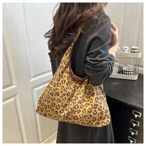 Detail view of the soft leopard print suede material and brown leather trim on hobo bag