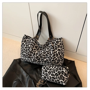 Detail of zebra leopard print tote bag set with black leather handles and gold chain