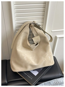 Gros plan détaillé du sac hobo en daim beige avec logo et texture mate très douce