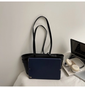 Grand cabas noir en cuir présenté avec une tablette pour montrer sa grande capacité