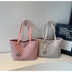 Detail of pink and beige leather tote bags with M-letter prints and gold metal pendants