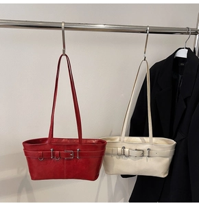 Détail des sacs cabas en cuir rouge et crème avec ceinture décorative et boucles métalliques