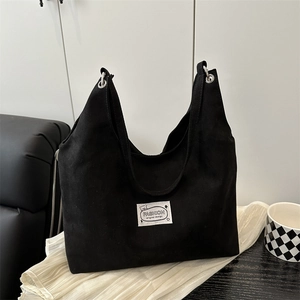 Minimalist black suede tote bag with fashion label on modern home background