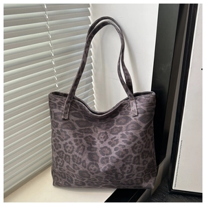 Detail showing high-capacity grey leopard print tote bag in natural light window setting