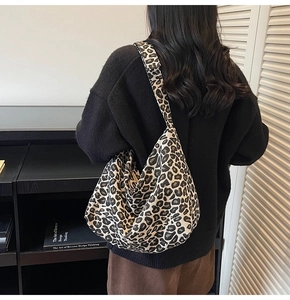 Detailed view of the large leopard print shoulder bag worn on the back of a model