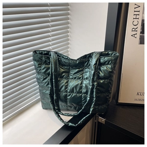 Detailed view of deep green quilted tote bag with glossy finish and square stitching
