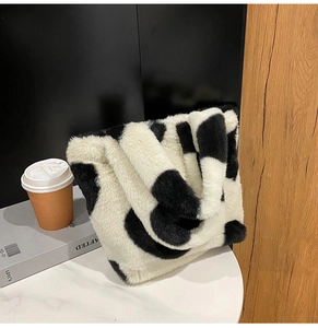 Détail d'un sac cabas en peluche à motif vache noir et blanc pour l'automne et l'hiver