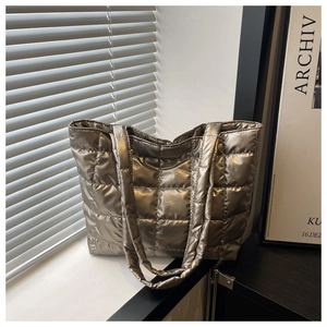 Close-up of quilted puffer tote bag in metallic champagne gold with waterproof fabric