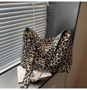 Detail of leopard print canvas shoulder bag with metallic buckle and wide strap