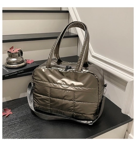 Quilted bronze travel bag with thick top handles and detachable grey woven shoulder strap