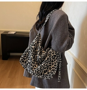 Detailed view of leopard print tote bag with wide strap on a model shoulder