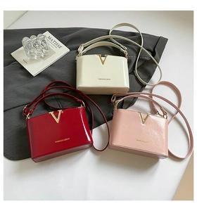 Three elegant leather bags in white, red and pink shown with golden V metal hardware