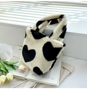 Gros plan sur un sac à main en peluche à motifs cœurs sous l'ombre de persiennes
