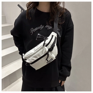 Détail de la sangle noire réglable et de la boucle sur le sac en nylon blanc minimaliste